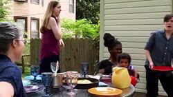 MS TU PAN Smiling family serving dinner at table on patio in backyard of home Stock Footage