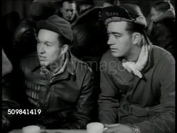 1942: DEBRIEFING REPRISAL: VS Air Force Airmen being asked, answering questions, how many seen, what kinds, how many 'kills', rockets, believe able to reload from inside. Instructional Video