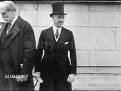 1921: WASHINGTON NAVAL CONFERENCE: Secretary of State Charles Evans Hughes w/ unidentified man BG, MS Group of men outside hall, TU WS Flags of attending nations hanging over roof edge.   Disarmament meeting, nine nations, not Russia. Instructional Video