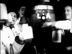 B/W 1933 dolly shot away from men pouring beer into mugs from barrel + toasting / repeal of Prohibition Stock Footage