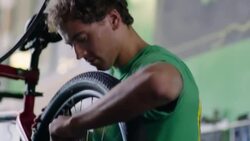 Young bicycle mechanic tightens screws and squeezes brake levers in bike shop Stock Footage