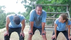 Tired team bending and resting on boot camp obstacle course Stock Footage