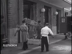 1940s: VATICAN CITY: SUPPLIES: Males carrying food baskets & milk containers into shop, loading truck. INT Apothecary w/ people shopping. Imported goods, food. Instructional Video