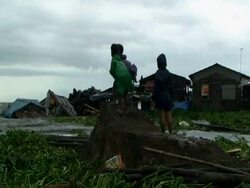 Children watching water flood into shanty houses, wide shot, Philippines, Typhoon Mirinae 2009 Stock Footage