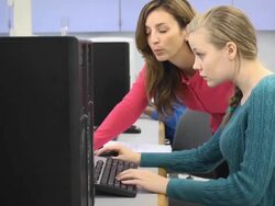 Teacher Assists Female Student in Computer Lab Stock Footage