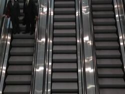 HA Two business associates riding down one of three escalators / Seattle, Washington, United States Stock Footage