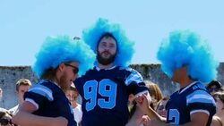 MS Three men wearing football team jerseys and wigs high fiving and chest bumping in stadium stands Stock Footage