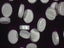 SLOMO CU paracetamol pills falling through frame, black background Stock Footage