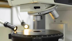 panning: close up to microscopy slide under orange light Stock Footage