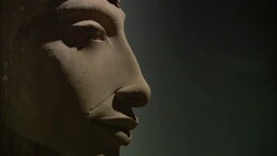 Shadows emphasize the prominent cheekbone of an ancient carving of a face in profile. Stock Footage