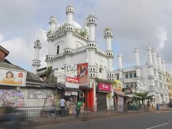WS T/L View of  traffic zips past Dewatagaha Mosque (also called Shaikh Usman Waliyyullah Shrine), one of the most sacred mosques  Stock Footage