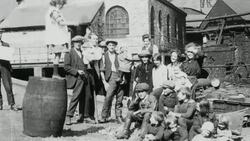 1921 MONTAGE Little girl on a barrel conducting a group of children singing for a few miners, and a singer playing her lute for neighbors and children during the coal strike / London, England Stock Footage
