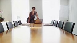 Businesswoman at end of conference table using laptop Stock Footage