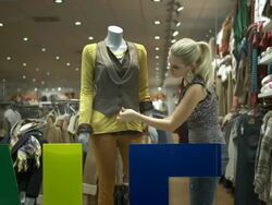 HD DOLLY: Window Dresser Adjusting Clothes On Mannequin Stock Footage