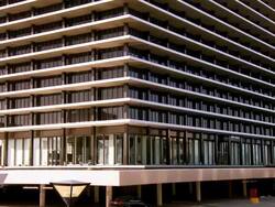 WS TU car entering parking space underneath 17-story glass and steel high-rise headquarters of Department of Water and Power building completed in 1965 / Los Angeles, California, USA Stock Footage