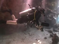 Diver (Liam Allan) swims through coral cave into shafts of light  Stock Footage