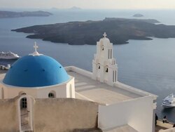 Blue Dome of the local church and the white washed houses of Thira at overlooking the Aegean Sea on the Island of Santorini, Greece, Europe Stock Footage