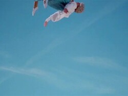 Wide shot young woman dressed as old woman jumping on trampoline Stock Footage