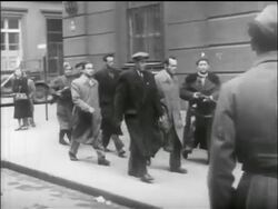 B/W 1956 PAN group of men walk on sidewalk / one with rifle / Hungarian uprising Stock Footage