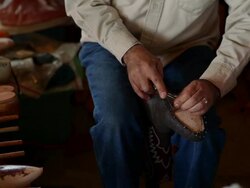 R/F PAN MS boot maker trimming excess leather from sole of cowboy boot Stock Footage