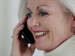 CU senior woman on mobile phone laughing and smiling Stock Footage