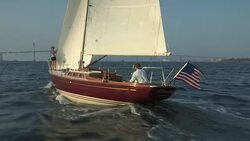 A woman walks to the bow of a Morris Yachts M36 as it sails through Narragansett Bay near Newport. Stock Footage
