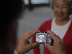 CU SELECTIVE FOCUS Elderly woman having her photo taken by man / China Stock Footage
