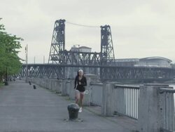 MS Shot of young female jogger stands on water front park and begins her morning jog / Portland, Oregon, United States  Stock Footage
