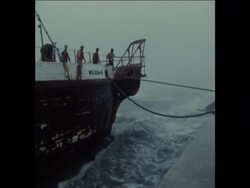 SYND 30 11 74 CREW TRY TO SECURE SHIP BROKEN FREE OF ITS MOORING News Clip