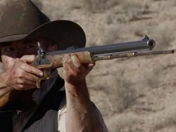 Slow motion of cowboy looking down rifle barrel and firing a shot. Stock Footage