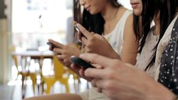 Three young women texting in cafe Stock Footage
