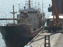 Crane loads cargo onto a ship moored at a dock, Hong Kong Stock Footage