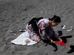 Japanese woman digging old records from sand Stock Footage
