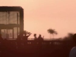 An exhaust pipe from a bus distorts the view of people walking on top of the Highline park in the evening Stock Footage