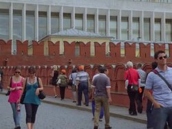 Pan across tower on Kremlin wall to tourist walking Stock Footage