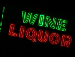 Blinking neon sign Wine Liquor  Sign is working improperly and flickering.  People walking through Stock Footage
