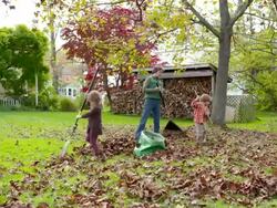 WS DS Grandmother with grandson and granddaughter raking leaves / Tivoli, New York, United States Stock Footage