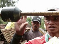 MS Miner weighting his basket with solid sulfur / Ijen, Java, Indonesia Stock Footage