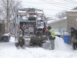 WS Sanitation workers working in snow covered alley Stock Footage