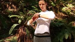 A young women running, working out, stretching and checking her mobile device outdoors on a sunny day. Stock Footage