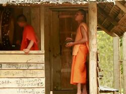 MS SLO MO Shot of two novice monks playing music one playing gong and other cymbals / Mountain village near Muang Ngoi, Luang Prabang, Laos Stock Footage