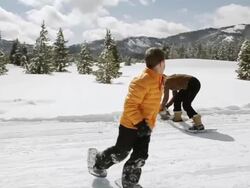 WS PAN SLO MO Young mother and son having fun and snowball fight out on beautiful winter's day / Sun Valley, Idaho, United States Stock Footage