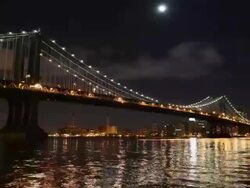 Moon high in sky over manhattan bridge with clouds Stock Footage