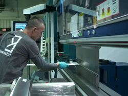 Profile medium of shot of man bending a piece of metal, partly in fast motion. Camera dollies in and out. Stock Footage