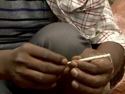 Ethiopian man rolls cigarette at market Stock Footage