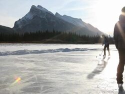 Couple play hockey on frozen mtn lake, woman scores Stock Footage