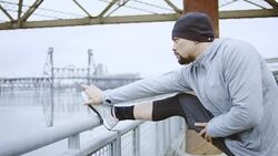 Ethnic adult male stretching before exercise in the city Stock Footage