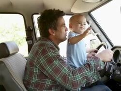 Father and baby son pretending to drive car Stock Footage