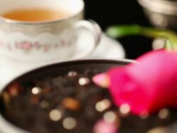 ECU R/F Rose on black tea leaves and cup of tea / Seoul, South Korea Stock Footage