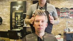 Male Hair stylist finishing a male clients hair Stock Footage